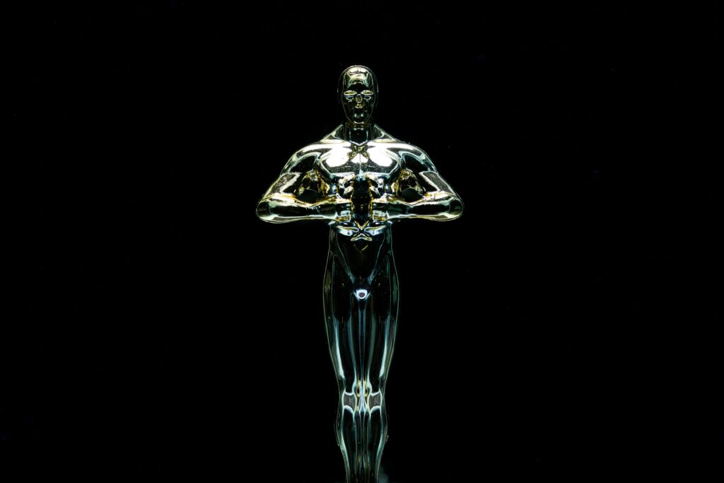 A golden trophy statue isolated on a black background symbolizing achievement and victory.