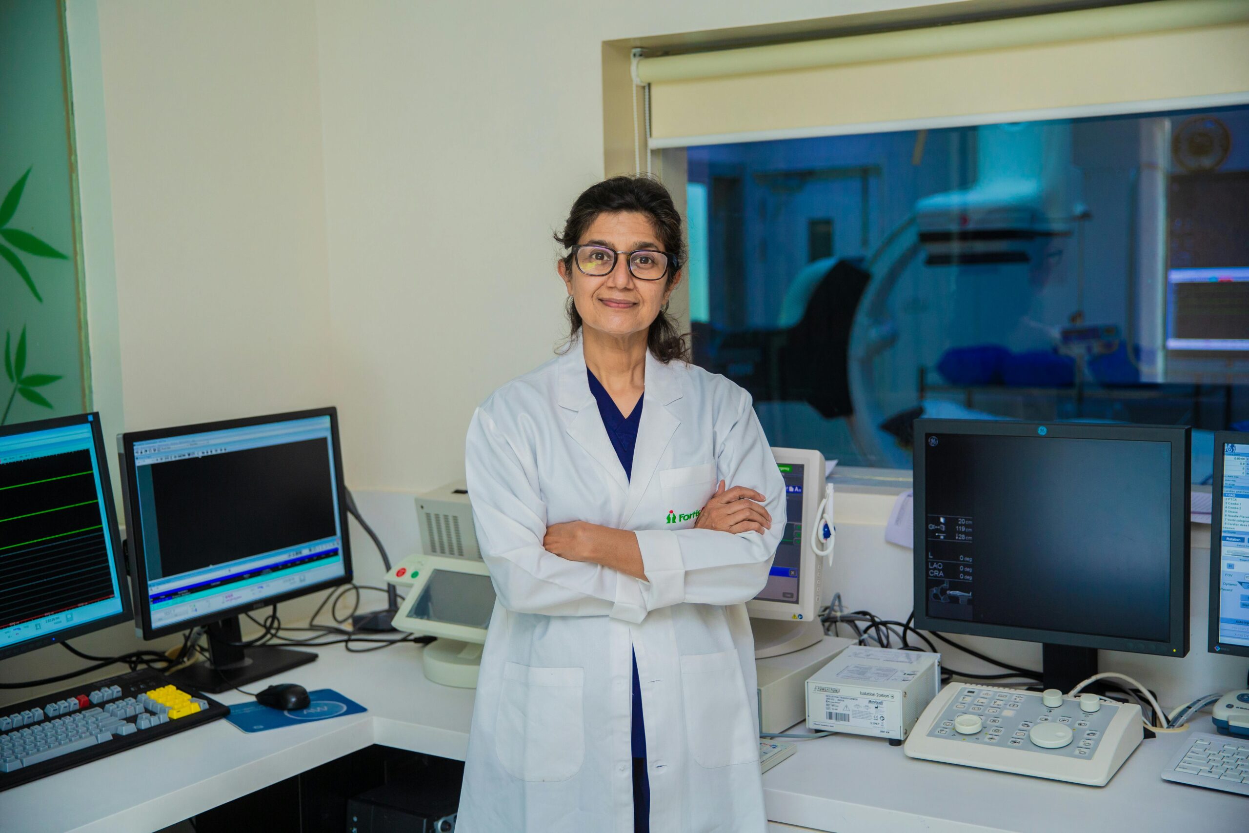 Confident female doctor with arms crossed in a modern medical laboratory setting in Delhi, India.